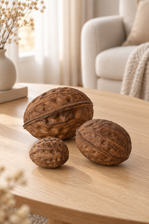 Dekorative Walnüsse aus dunklem Nussbaumholz auf einem Holztisch in wohnlicher Umgebung